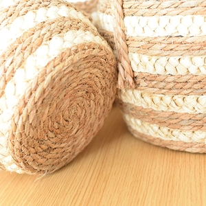 Detail view of woven seagrass plant basket with natural and white bicolor spiral pattern