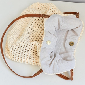 Detail of woven beach tote showing magnetic closure, cotton lining and leather straps