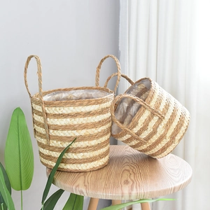 Detail of two handmade seagrass baskets with striped design and waterproof plastic liners