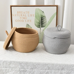 Detailed view of handmade cotton rope storage baskets with lids in grey and khaki