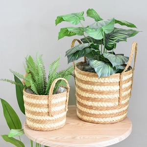 Close-up of woven straw plant baskets with handles and waterproof plastic liners