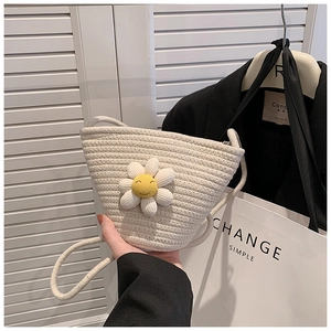 Detail of handwoven cream straw bag featuring a 3D daisy flower with a smiley face