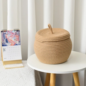 Detail of handmade cotton rope pumpkin basket with lid and handle for home storage