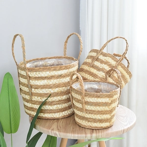 Three-piece nesting set of striped seagrass woven baskets with circular handles and liners