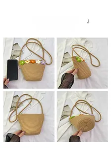 Detail view of handmade woven straw bucket bag featuring colorful crochet flower decorations