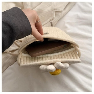 Close-up of the magnetic snap closure and woven interior of the daisy straw phone bag