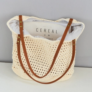 Close-up of woven beach tote interior showing large capacity and brown leather handles