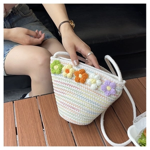 Detail shot of hand-woven crossbody bag with colorful crochet flowers and soft cotton strap