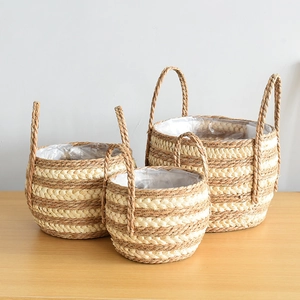 Three-piece set of woven seagrass plant baskets with handles and waterproof liners