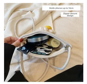 Interior view showing capacity for a 16cm phone and zipper closure on woven daisy bag