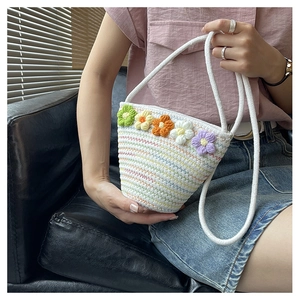 Detail of handmade crochet shoulder bag with colorful floral decor and rainbow stitching