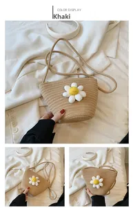 Close-up of khaki straw woven crossbody bag with decorative white daisy flower detail