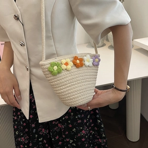 Detailed close-up of handmade woven crossbody bag with colorful crochet floral accents