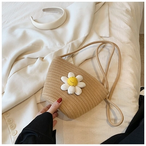 Close-up of handmade straw crossbody bag featuring a white daisy flower with a smile