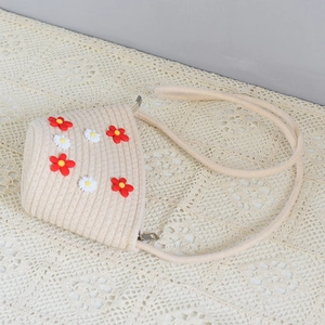 Detail shot of hand-woven beige round bag with 3D floral appliques on lace background