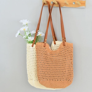 Detail of hand-woven mesh tote bags in cream and brown with reinforced leather handles