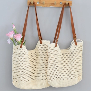 Close-up of woven mesh beach tote bag with brown faux leather straps and metal rivets