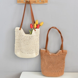 Detail of hand-woven crochet beach tote bags with leather straps and metallic rivets