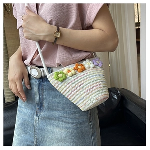 Detailed close-up of handmade crochet crossbody bag with 3D floral accents and woven texture