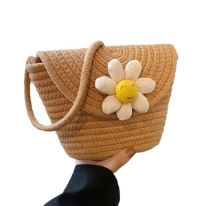 Cute woven crossbody bag for women with a brown rope texture and a smiley sun flower
