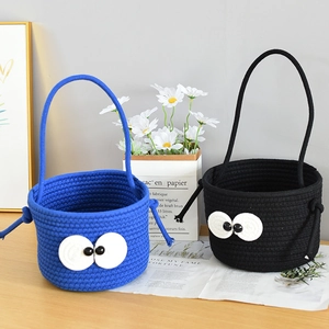 Detail of blue and black woven storage baskets with cute eye designs and long handles