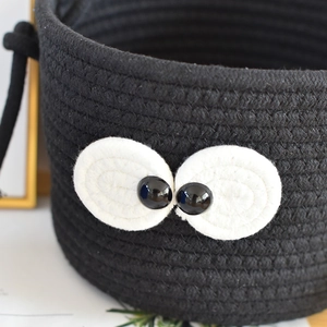 Detail of cute black woven storage bin with big eyes made of high-quality cotton rope