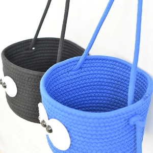 Detail of cute handmade cotton rope storage baskets with large decorative eyes and sturdy handles