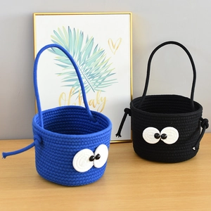 Detail view of handmade cotton woven storage baskets with cute cartoon big eyes and handles