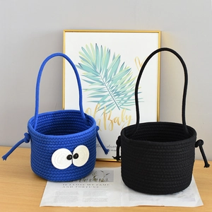 Detail of handwoven cotton rope basket with cute eye pattern and durable handles
