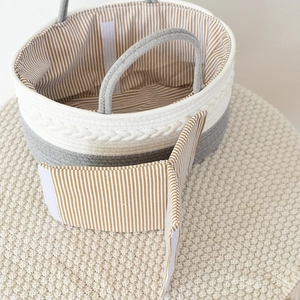 Detail view of woven cotton rope baby basket with grey-white striped fabric lining and divider