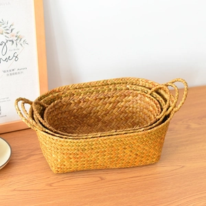 Detailed texture of handcrafted oval straw baskets in a three-piece nesting storage set