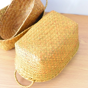 Macro view of woven storage baskets with handles on light wood surface in natural color