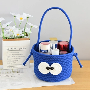 Detail of blue cotton rope storage basket with big eyes design and handle