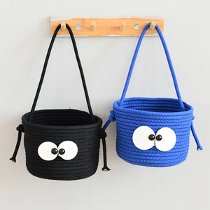 Detail of cute big eye handmade woven cotton rope storage baskets with long handles