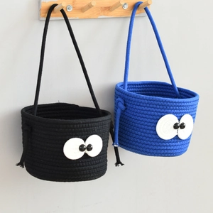 Detail of hanging cotton rope storage baskets with cute big eyes and sturdy handles