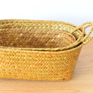 Detailed close-up of natural seagrass weave texture on a set of nesting storage baskets