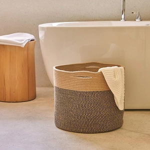 Detail view of woven cotton rope laundry basket with dual-tone beige and black texture
