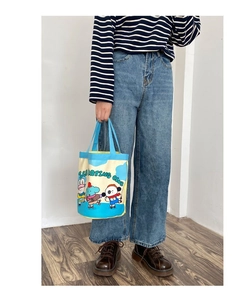 Close-up of canvas bucket bag featuring cute ice skating club animal illustrations