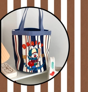 Detail of striped canvas bucket bag with rabbit sports illustration and blue handle