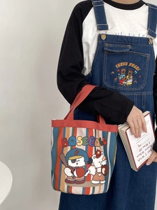 Detail of canvas tote bag featuring colorful stripes and cute cartoon baseball graphics