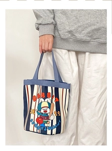 Detail of canvas bucket bag featuring a vintage cartoon rabbit print and retro typography