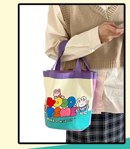 Detail view of canvas bucket bag with colorful doodle illustrations and purple handles