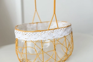 Detail of golden iron woven flower basket with white lace trim and waterproof liner