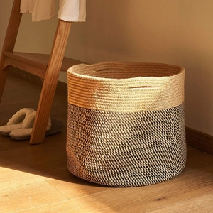 Detail of hand-woven cotton rope storage basket with two-tone design and built-in handle