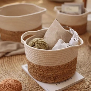 Detail of handwoven cotton rope and jute storage basket with handles in a cozy home setting