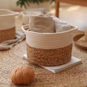 Detail of a two-tone woven basket with cotton rope handles on a round braided rug