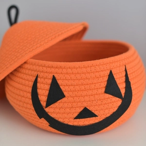 Close-up detail of the woven cotton rope texture and pumpkin face design on the storage basket
