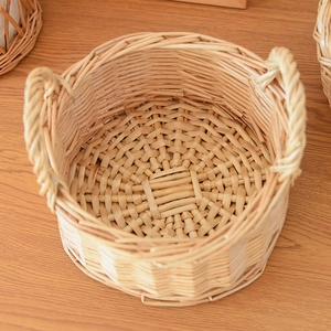 Top view of natural woven willow basket with dual handles on a light wooden table