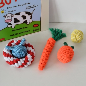Close-up of five colorful cotton woven rope toys for pet dogs including carrot and ball shapes