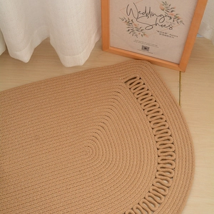 Detail of a handmade semi-circular cotton rope rug with an intricate hollow-out woven edge